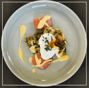 Teller mit grünem Spargel, geräuchertem Lachs, pochiertem Ei und Sauce Hollandaise 