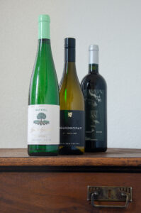 Foto der Verkostungsweine Riesling Kabinett Große Gefühle 2021, Chardonnay Exquisit 2020 und Cuvée Titan 1999