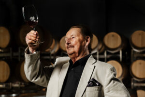 Heribert Bayer mit einem Glas Rotwein in der Hand