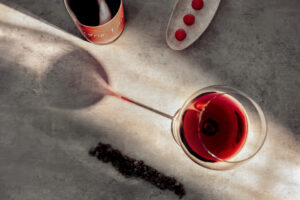 Ein Glas Pinot Noir In Signo Tauri mit der In Signo Tauri Flasche, Himbeeren und Gewürze