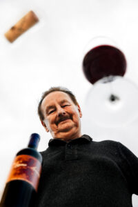 Heribert Bayer mit einem Glas In Signo Leonis und In Signo Leonis Flasche